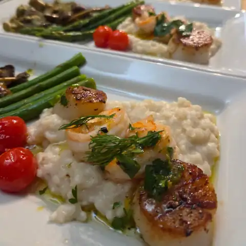 Seared scallops and shrimp over risotto with asparagus at a private chef dinner in Asheville NC
